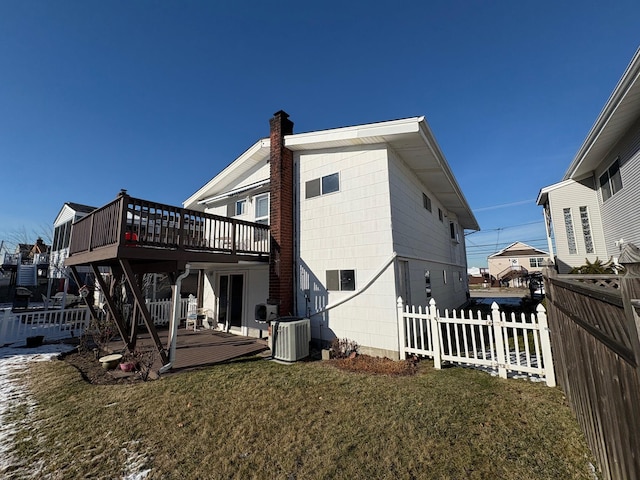 back of house featuring a yard, cooling unit, and a wooden deck