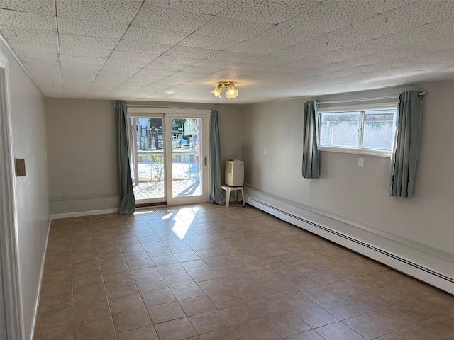 empty room with light tile patterned floors and a baseboard radiator