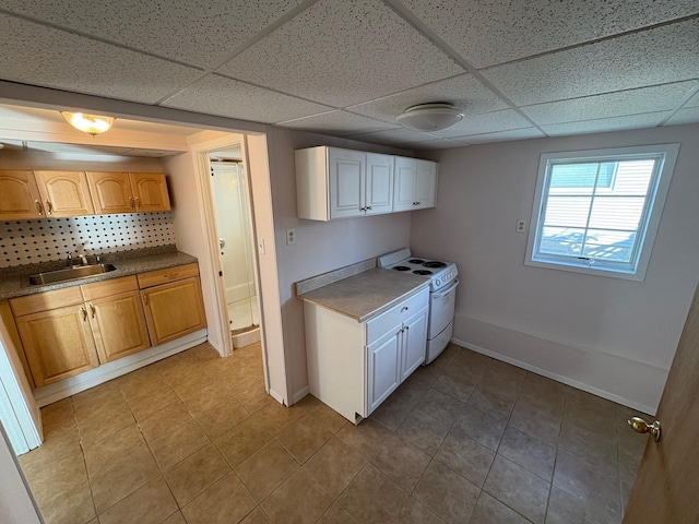 kitchen featuring electric range, a drop ceiling, light tile patterned floors, and sink