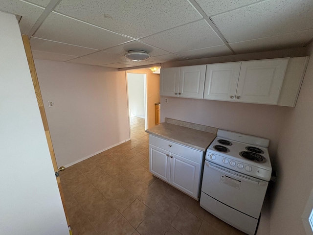 kitchen with a paneled ceiling, white cabinets, and electric range oven