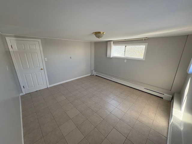 spare room featuring baseboard heating and light tile patterned flooring