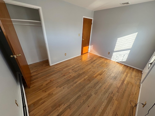 unfurnished bedroom with light wood-type flooring and a closet