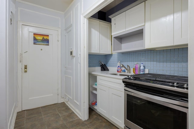 kitchen with white cabinets, stainless steel range oven, sink, and tasteful backsplash