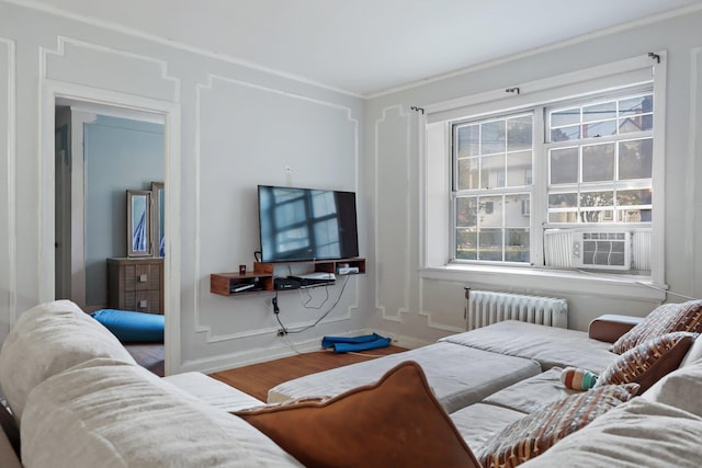 living room with radiator, a wealth of natural light, hardwood / wood-style floors, and cooling unit