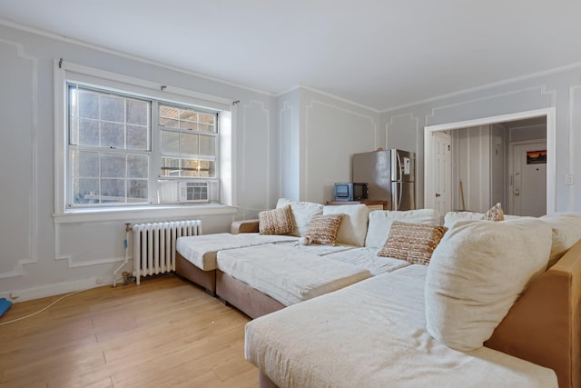 bedroom with light wood-type flooring, stainless steel refrigerator, radiator, and crown molding