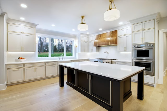 kitchen featuring custom range hood, stainless steel appliances, a kitchen island, hanging light fixtures, and a breakfast bar area