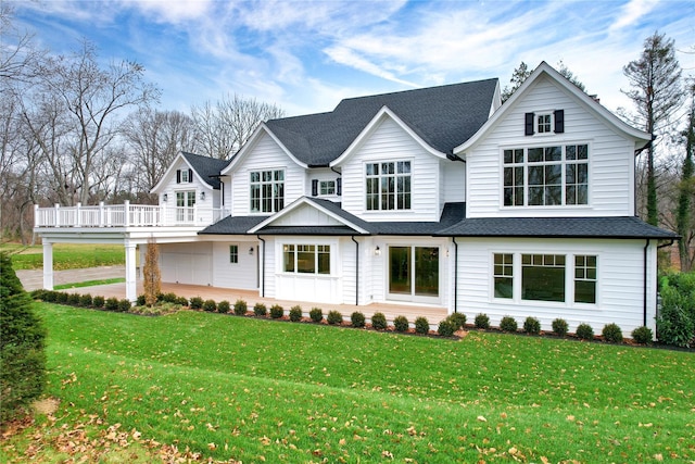 rear view of property featuring a lawn and a garage