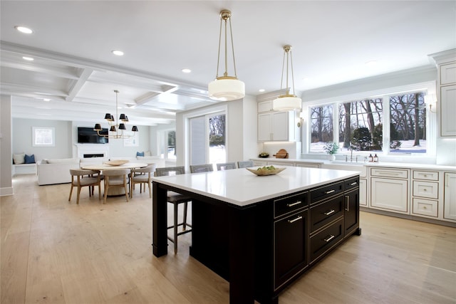 kitchen featuring white cabinetry, decorative light fixtures, and a center island