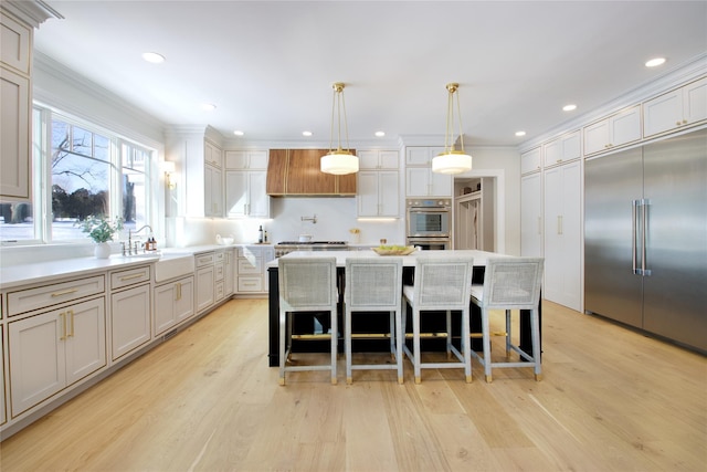 kitchen with decorative light fixtures, a kitchen island, a breakfast bar area, and appliances with stainless steel finishes