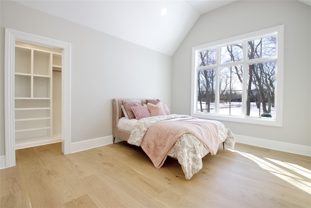 bedroom featuring lofted ceiling and light wood-type flooring