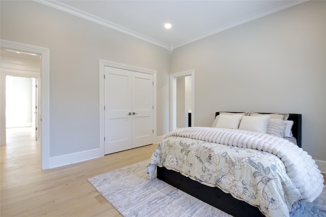 bedroom featuring ornamental molding, light wood-type flooring, and a closet