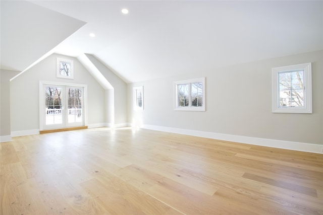 bonus room featuring french doors, lofted ceiling, a wealth of natural light, and light hardwood / wood-style flooring