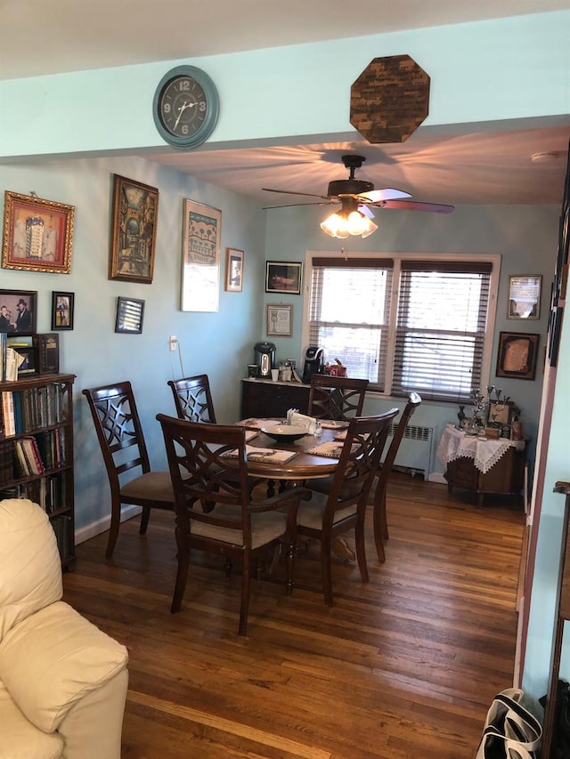 dining area featuring dark hardwood / wood-style floors, radiator, and ceiling fan