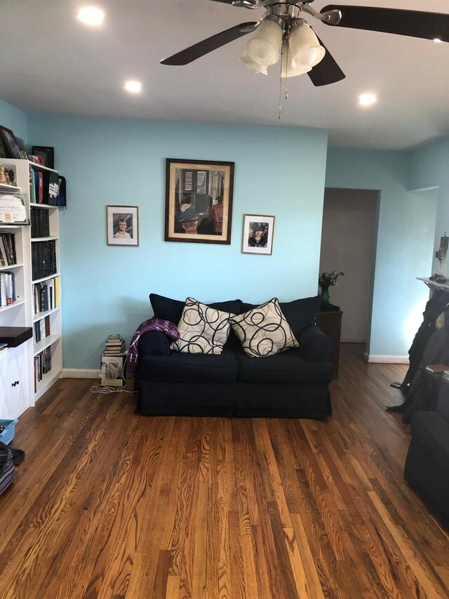 living room with dark hardwood / wood-style floors and ceiling fan