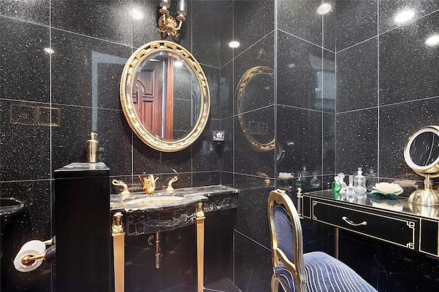 bathroom featuring sink and tile walls