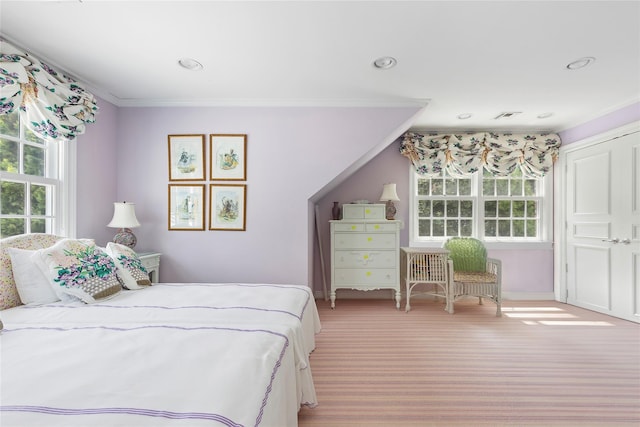 bedroom with ornamental molding and light carpet