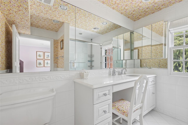 bathroom featuring tile patterned flooring, vanity, tile walls, and walk in shower