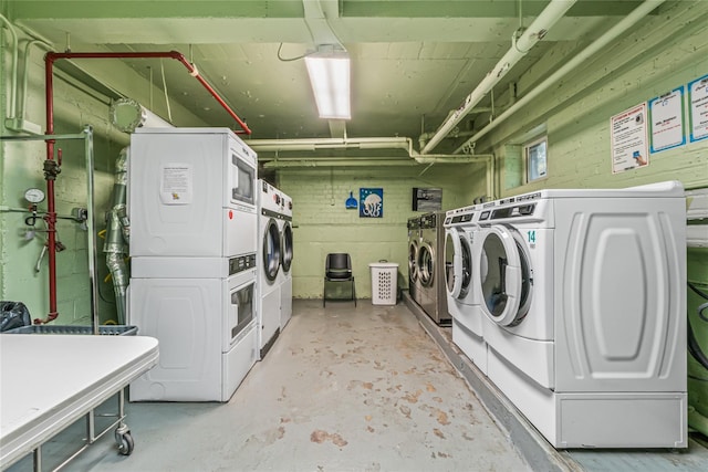 laundry area with stacked washer / dryer and washer and clothes dryer