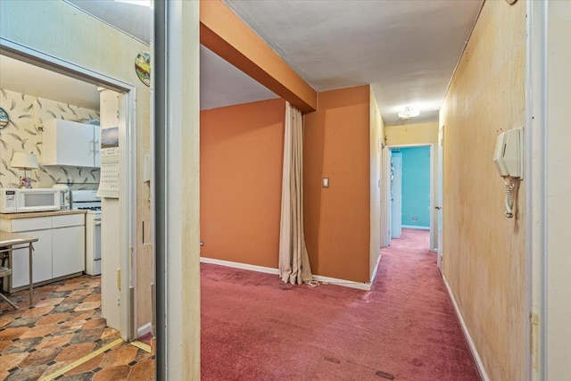 hallway with dark colored carpet