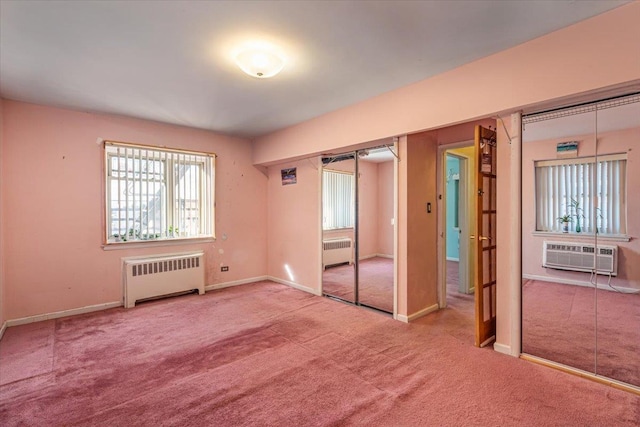 unfurnished bedroom with carpet flooring, radiator, and a closet