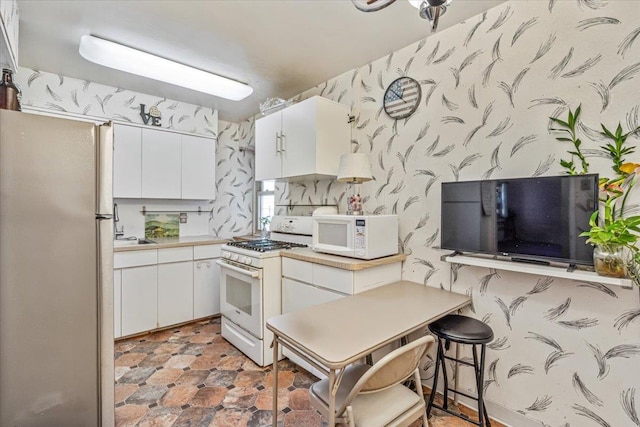 kitchen featuring white cabinetry and white appliances