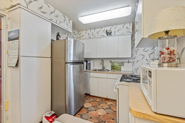 kitchen featuring sink, white cabinets, and stainless steel appliances