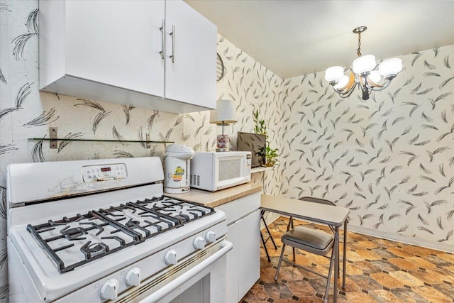 kitchen with white cabinets, white appliances, decorative light fixtures, and an inviting chandelier