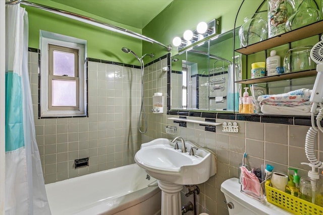 bathroom with tasteful backsplash, shower / bath combo, tile walls, and toilet