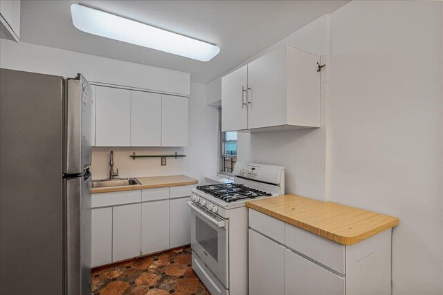 144-55Melbourne Ave 2F, Flushing, NY 11367 - kitchen featuring freestanding refrigerator, white gas range oven, white cabinets, and dark stone finish floors