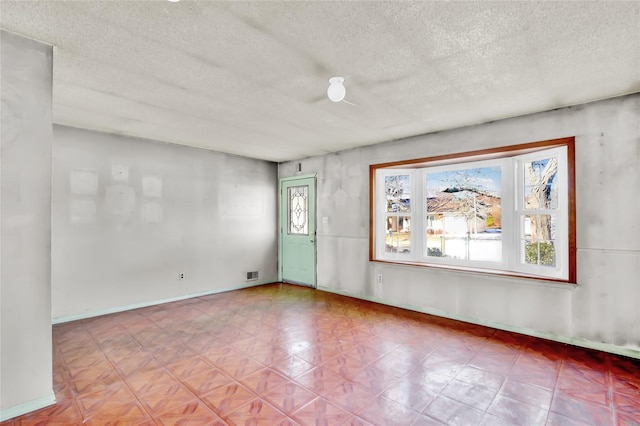 unfurnished room with a textured ceiling