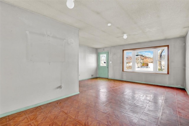 unfurnished room featuring a textured ceiling