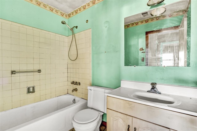 full bathroom with vanity, tiled shower / bath combo, and toilet