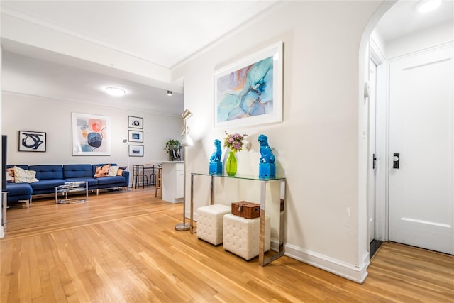 hallway with hardwood / wood-style flooring and crown molding