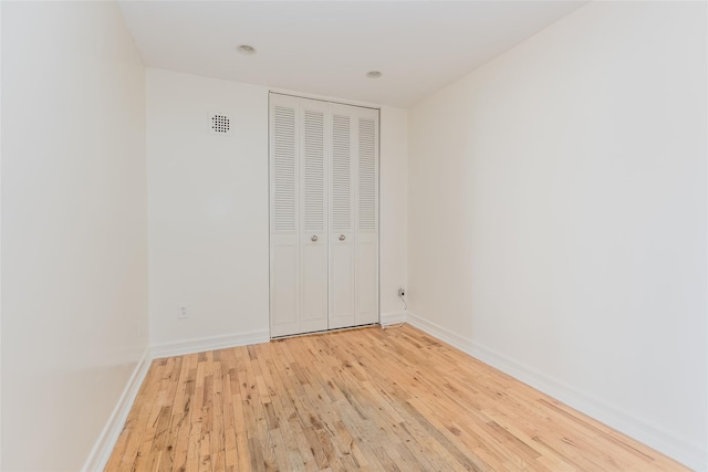 unfurnished bedroom featuring a closet and light hardwood / wood-style floors