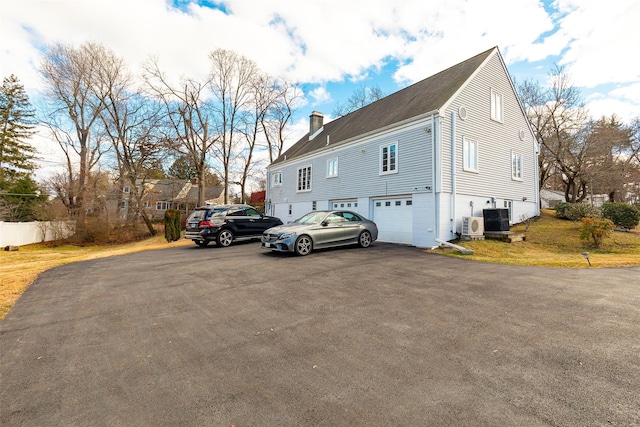 exterior space with central AC, ac unit, and a garage