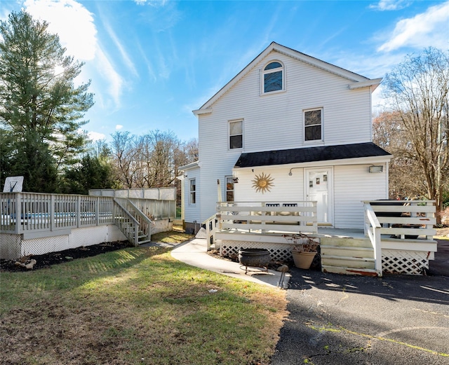 back of property featuring a lawn and a wooden deck