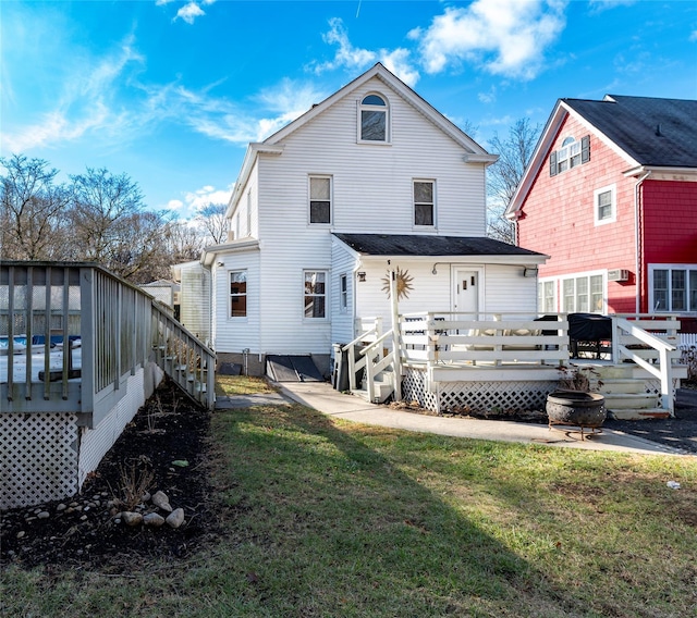 rear view of house with a lawn and a wooden deck