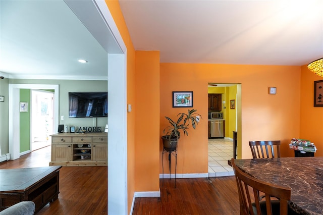 dining area with hardwood / wood-style flooring, ornamental molding, and baseboard heating