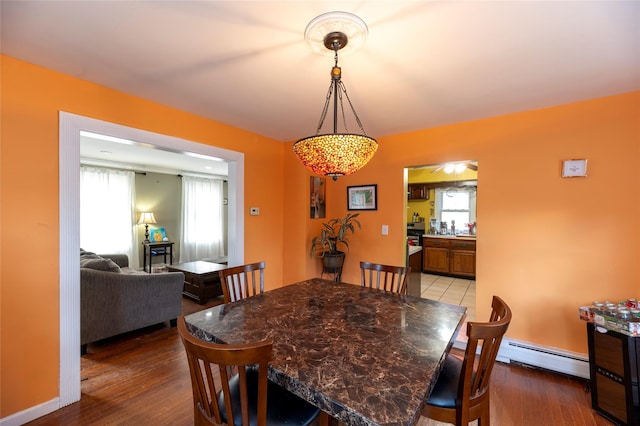 dining space featuring wood-type flooring and baseboard heating