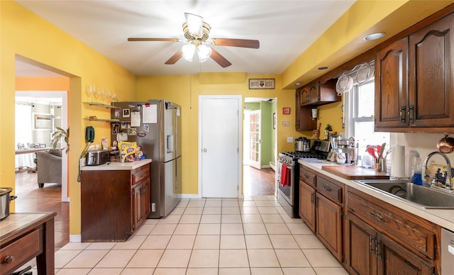 kitchen with light tile patterned floors, stainless steel appliances, ceiling fan, and sink