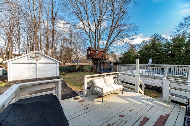 deck featuring a garage, an outbuilding, and a trampoline