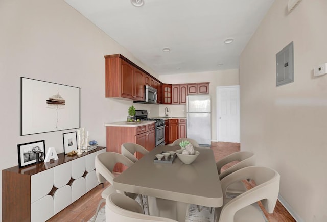 dining room with electric panel and light hardwood / wood-style floors