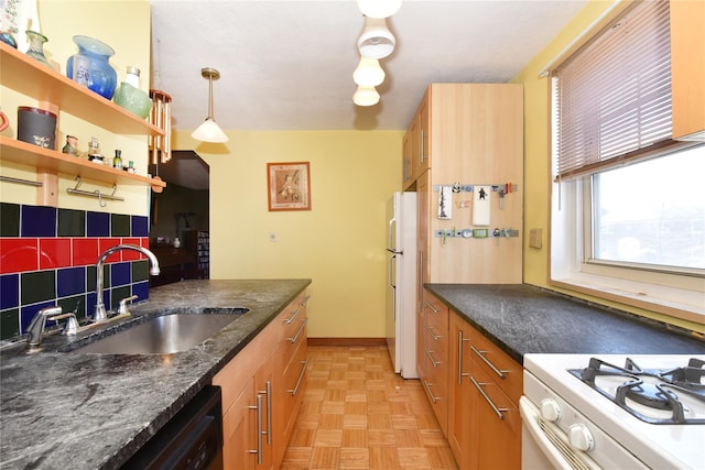 kitchen with sink, dark stone counters, decorative light fixtures, white appliances, and light parquet flooring