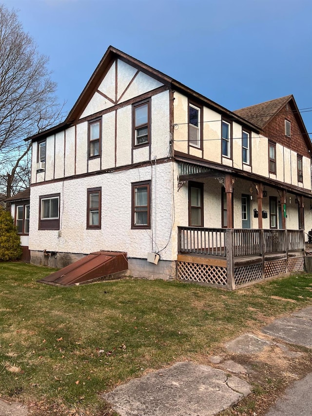 view of side of property featuring a lawn and a porch