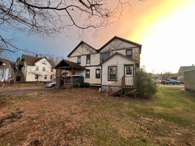 back house at dusk featuring a yard