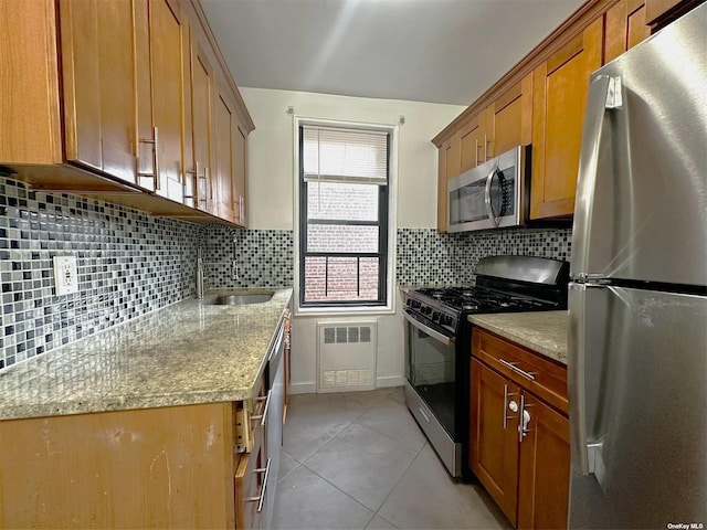 kitchen with decorative backsplash, light stone counters, and stainless steel appliances