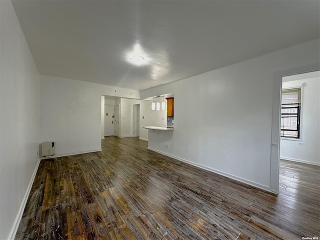 unfurnished living room with dark wood-type flooring