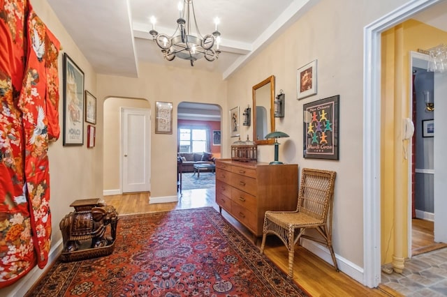 corridor with a notable chandelier and wood-type flooring