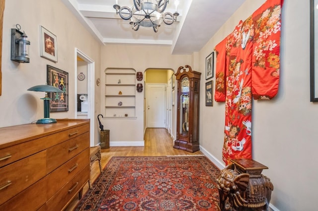 hallway featuring a notable chandelier and light hardwood / wood-style floors