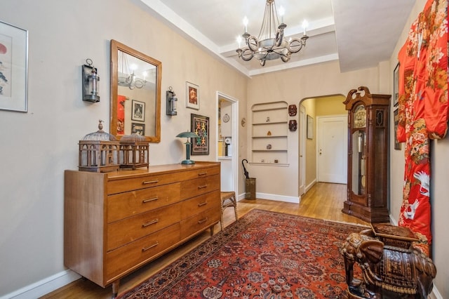 hall featuring a chandelier and light wood-type flooring